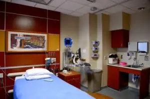 Hospital room with warm tones and blue bedding
