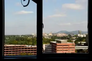 View from out of high window with buildings and mountains in the background.