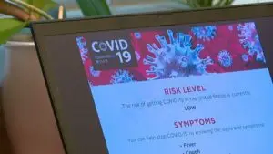 laptop screen with Covid 19 Symptoms and risk levels pulled up.