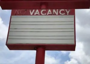 Red hotel sign with empty message board and neon lights turned off.