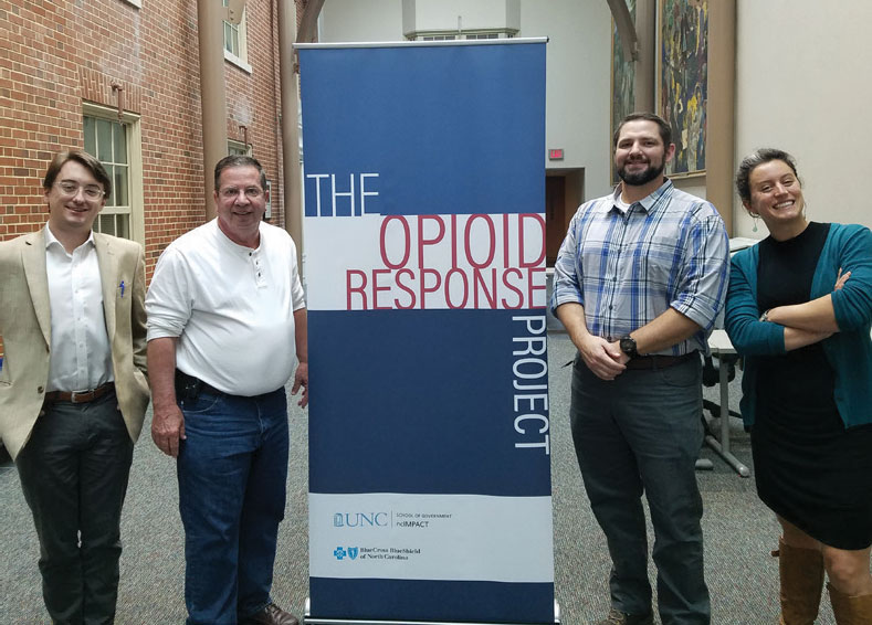Four C.A.R.E staff standing in front of sign that says "The Opioid Response Project"