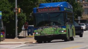 Blue and green city bus crossing at stop in downtown Asheville, NC