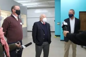 3 men in face masks speaking to the press.