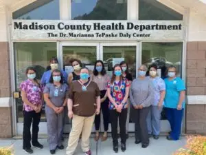 Staff members with face masks on standing infront of the Madison County Health Department - The Dr. Marianna Te Paske Daly Center