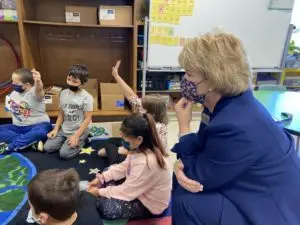 Woman observing elementary students