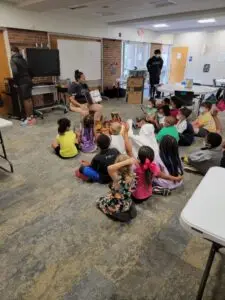 Woman reading to school children