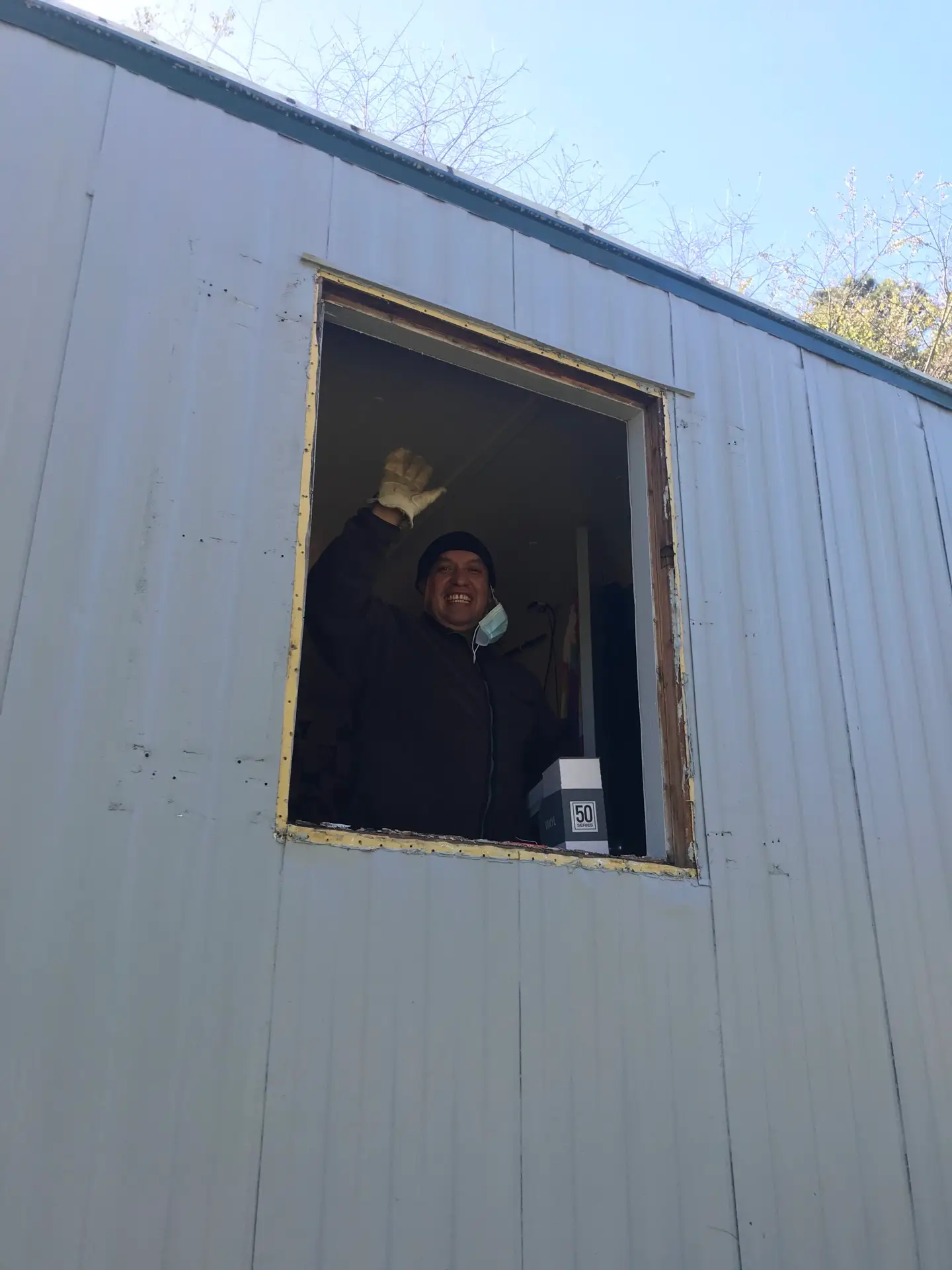 Volunteer waving from new house