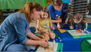 Teachers working with students on crafts