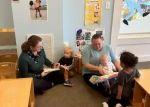 Teachers sit and play with toddlers