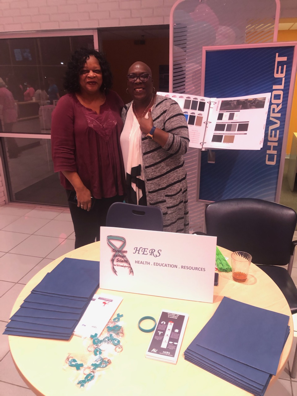2 Women showcasing their table about HERS organization