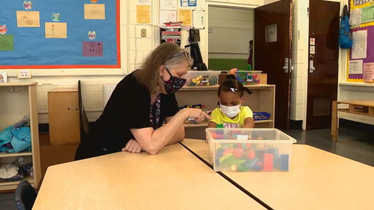 Teacher working with a child using building blocks