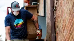 relief worker cleaning up after hurricane