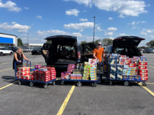 loading up multiple cars with cases of food and drink supplies for those affected by Hurricane Helene