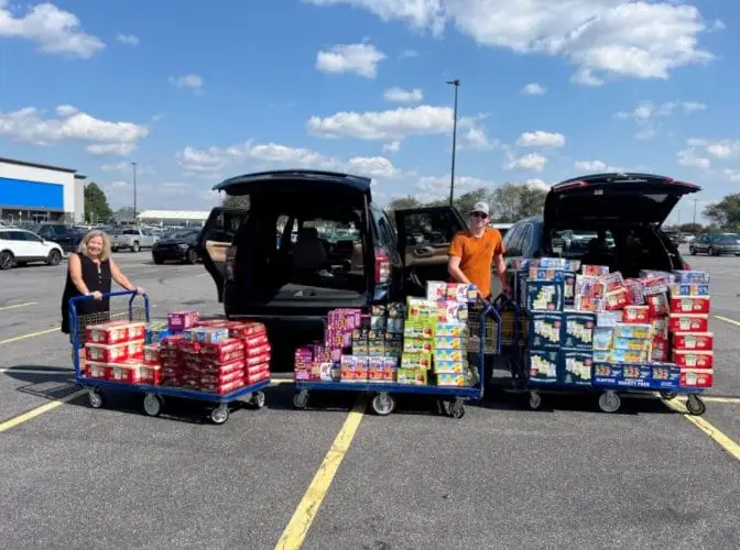 woman and man standing with carts of food purchased using relief funds in response to Hurricane Helene
