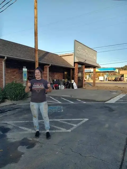 woman smiling giving thumbs up outside of Sandees cafe in Newland, North Carolina