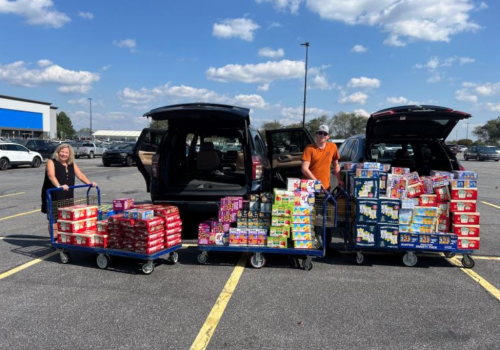 loading up multiple cars with cases of food and drink supplies for those affected by Hurricane Helene