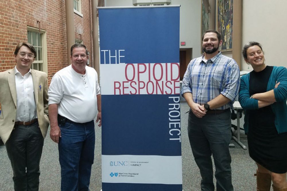 Four C.A.R.E staff standing in front of sign that says "The Opioid Response Project"